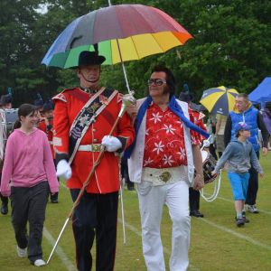 Elvis helps the Cinq Port Corps of Drums keep dry during their performance at Funfest