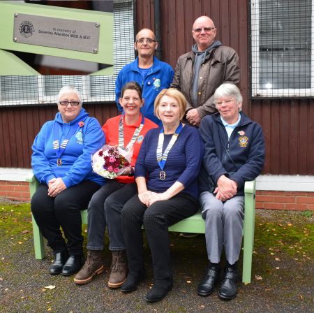 Representatives of the local Lions Clubs are pictured with the meorial bench. The tribute plate is inset top left.